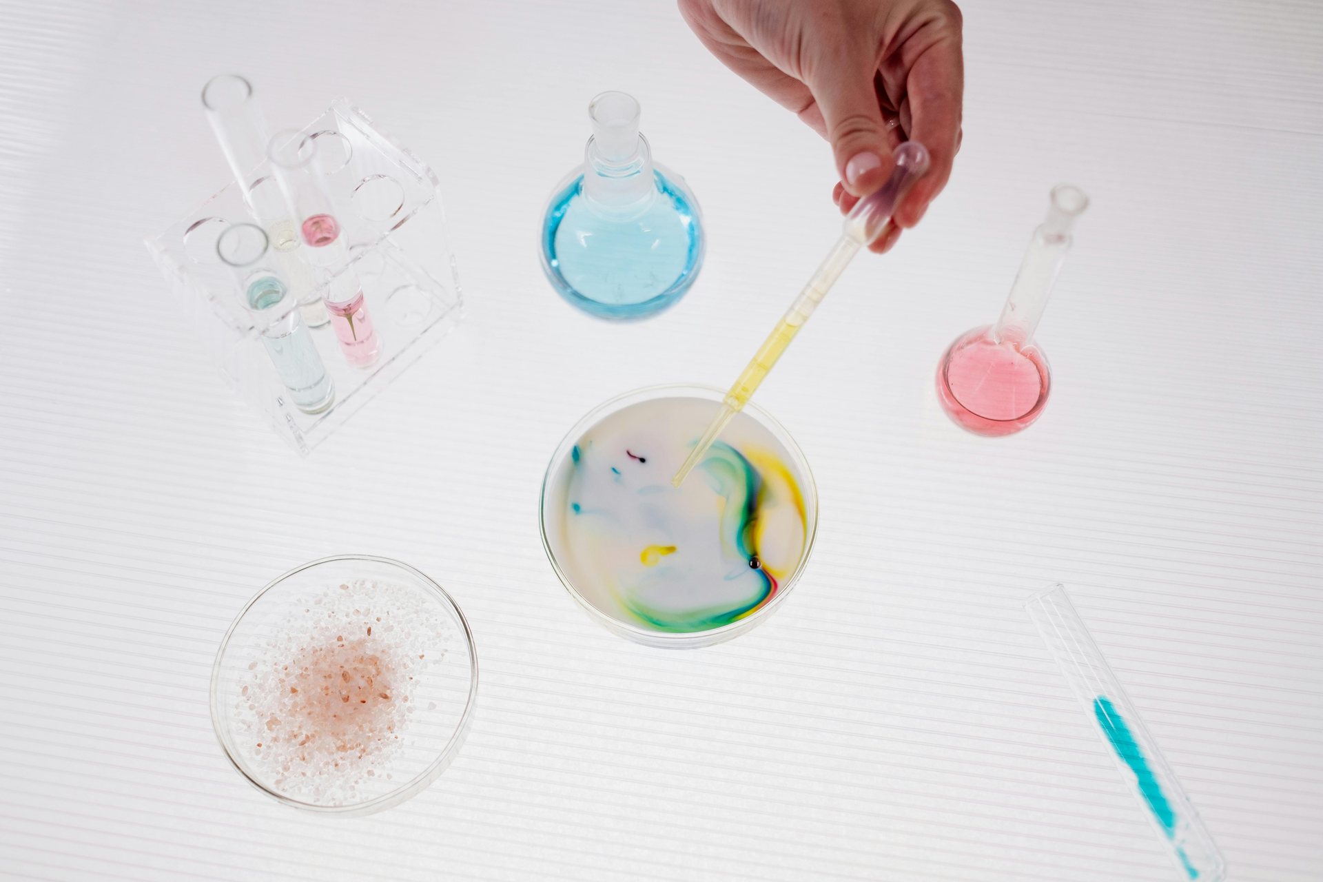 Colorful laboratory glassware laid out on a bright white bench