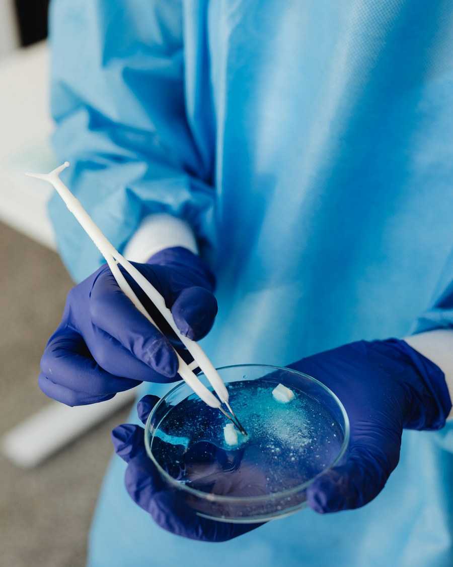 A gloved scientist preparing a sample in a petri dish