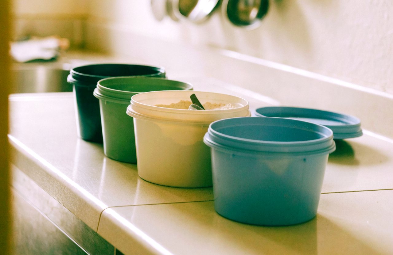 Unlabelled protein tubs lined up on a counter for comparison