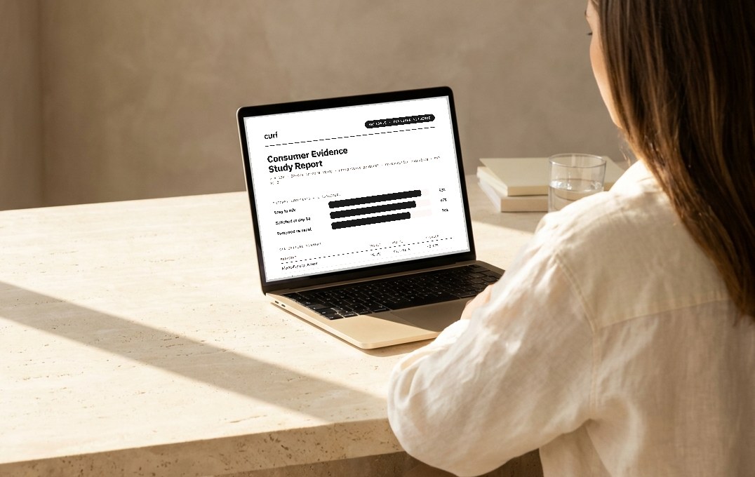 A researcher reviewing a curí Consumer Evidence Study Report on a laptop