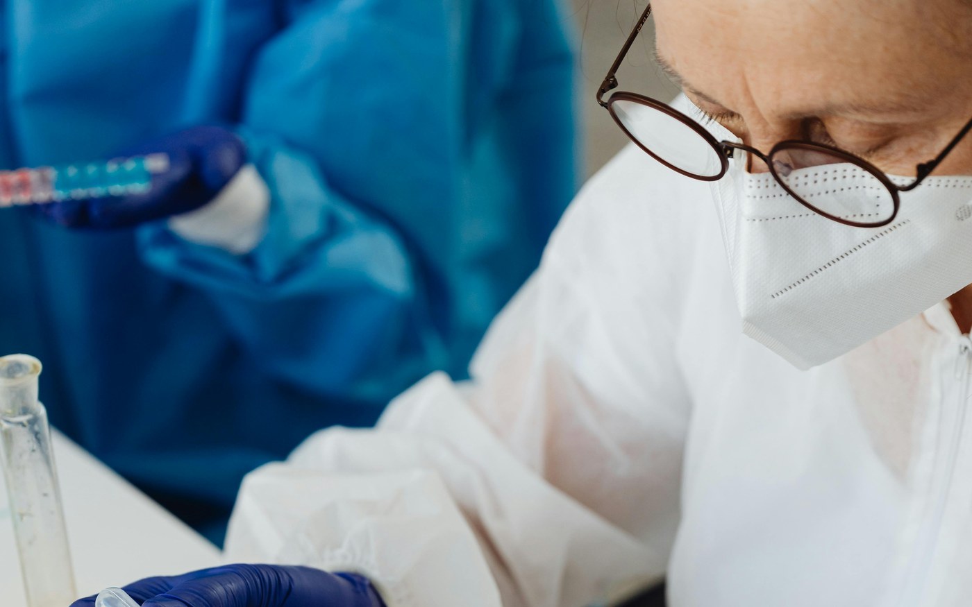 A scientist pipetting samples into a tube rack