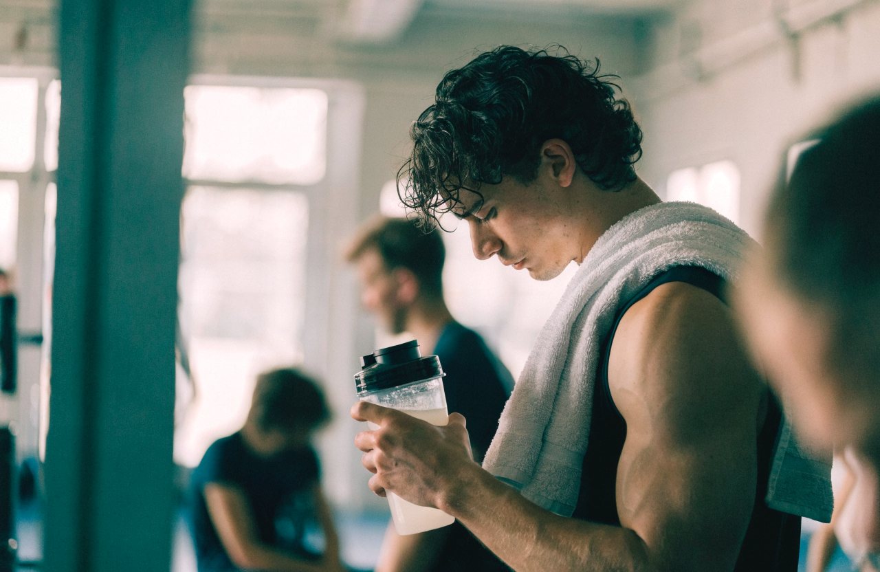 An athlete shaking a protein drink after training