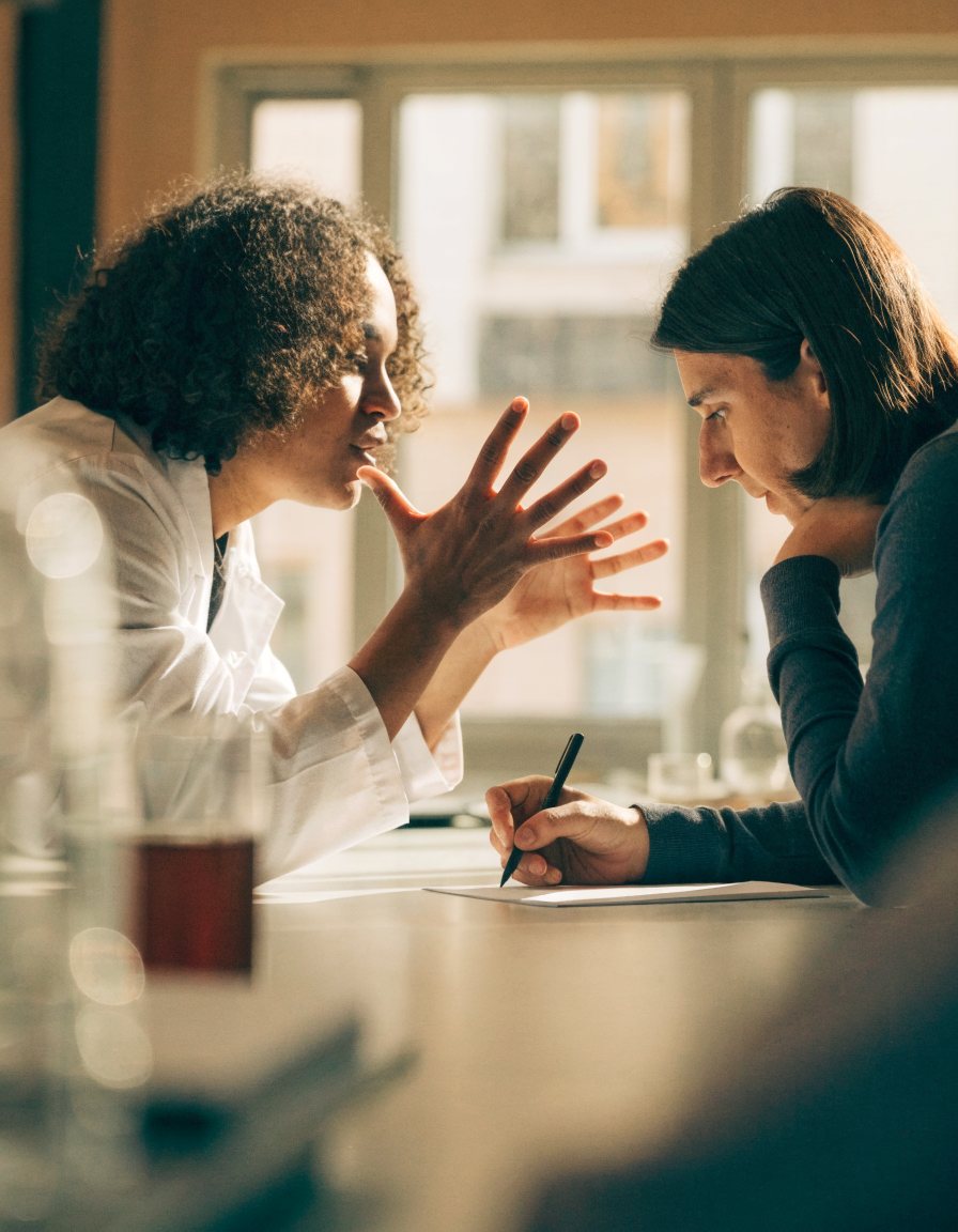 Two people talking across a laboratory bench