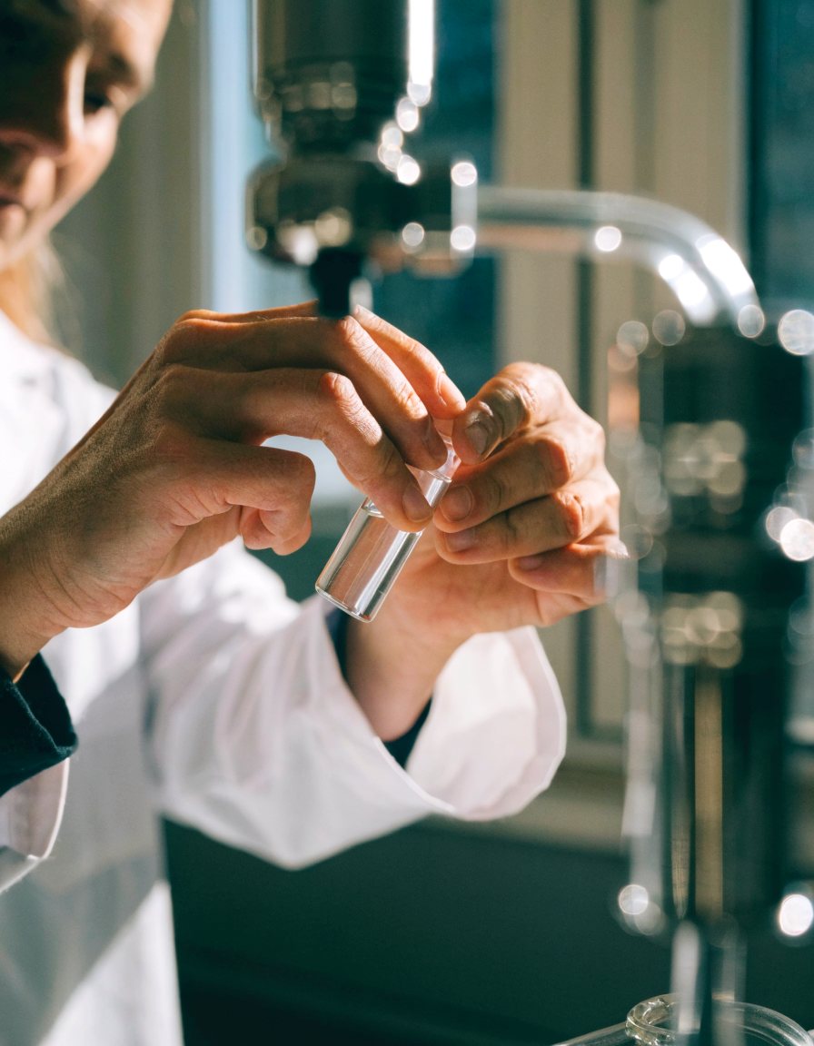A scientist loading a vial into an analytical instrument